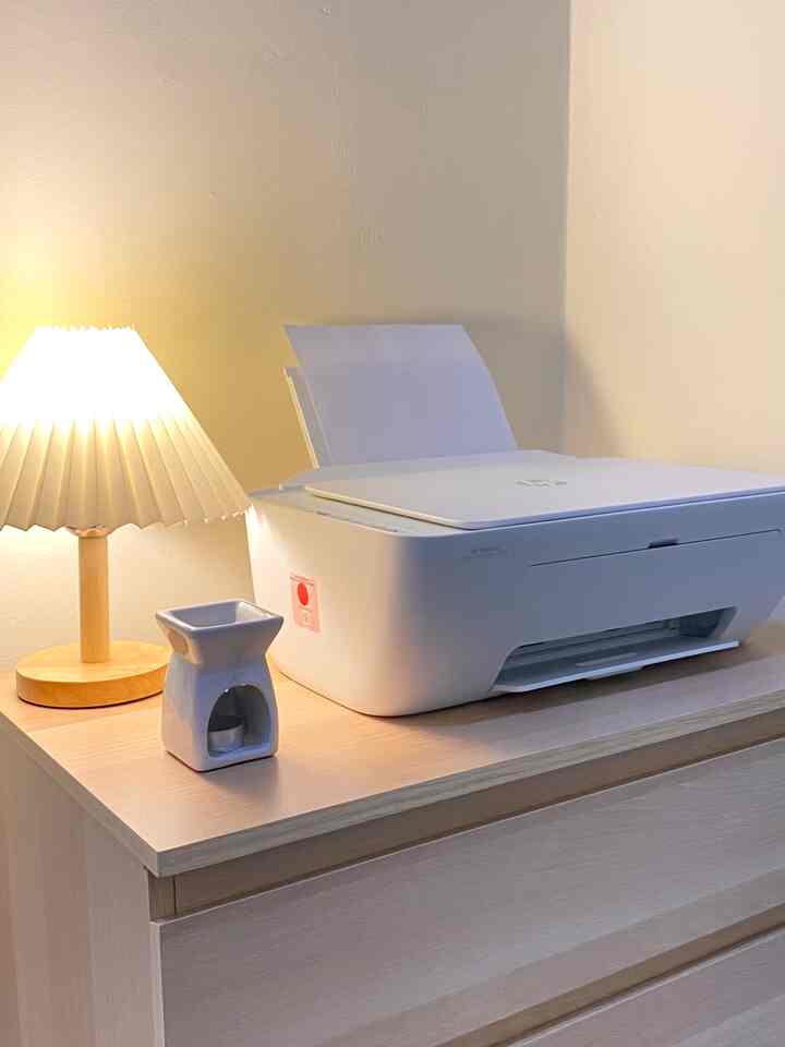 White and brown toned home office featuring a dresser with a printer and table lamp creating a cozy workspace