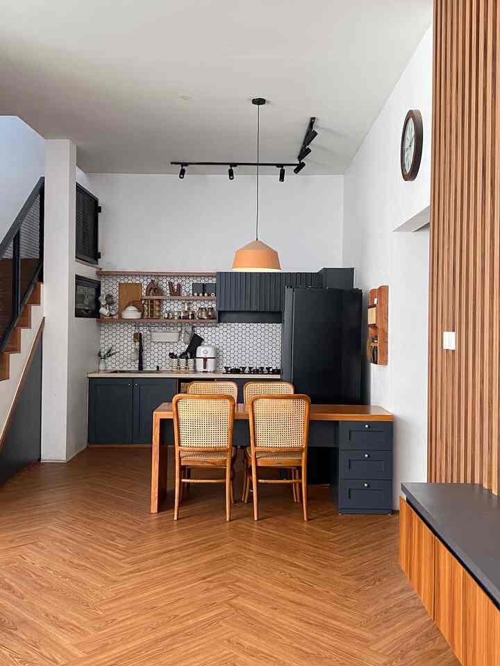 Wood tone and black kitchen and dining room featuring rattan dining chairs and pendant light in a Mid-Century Modern style space