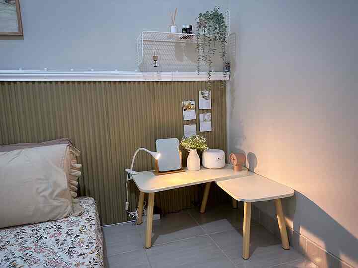 White and brown toned bedroom featuring a minimalist corner desk with warm lighting creating a cozy atmosphere
