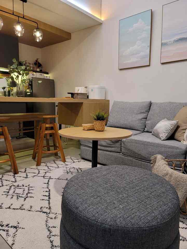 Gray and wood tone living room featuring minimalist Japandi style sofa and coffee table in a cozy natural setting