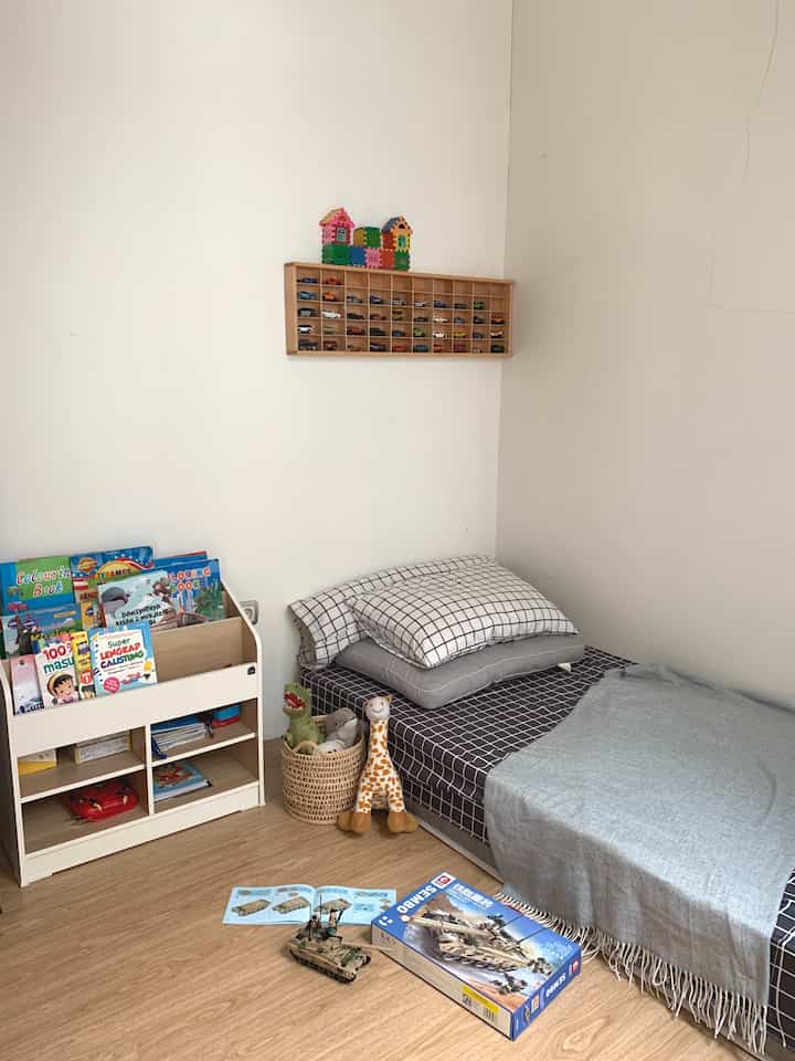 Bright natural-tone kids' room featuring checkered single bed and toy storage creating cozy atmosphere