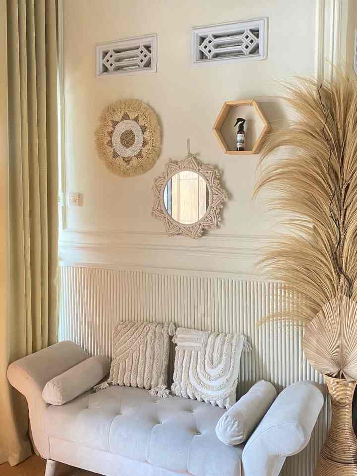 Natural beige-toned entrance space featuring a bohemian-style sofa, macrame mirror, and dried flowers with a cozy atmosphere