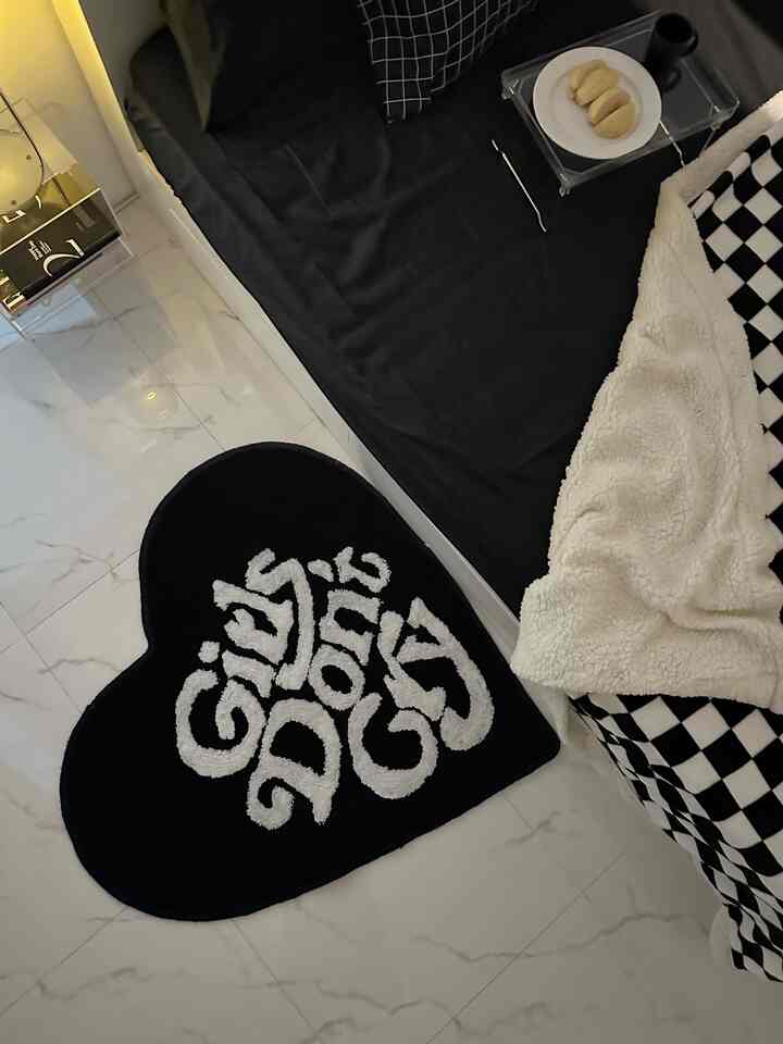 Monotone black and white bedroom featuring a simple bed and heart-shaped carpet with cozy atmosphere
