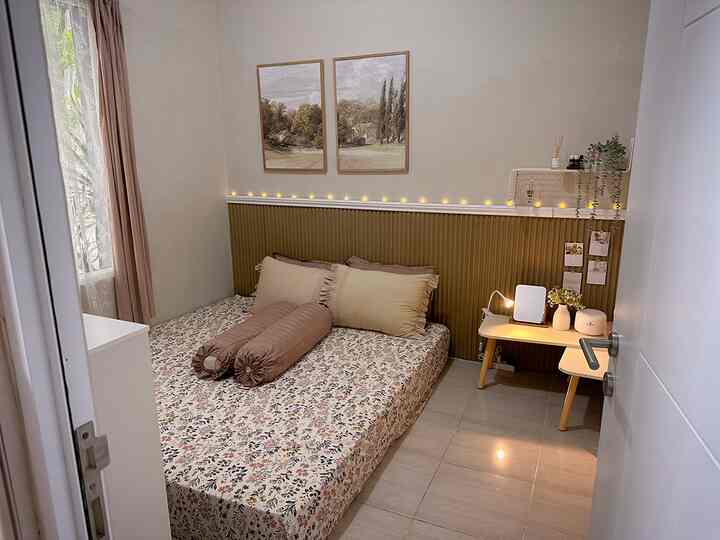 Beige and wood-toned walls with a floor bed and small coffee table in a cozy bedroom space