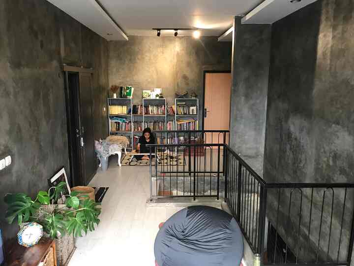 Gray-toned small reading space featuring black bean bag and metal bookshelves with an industrial atmosphere