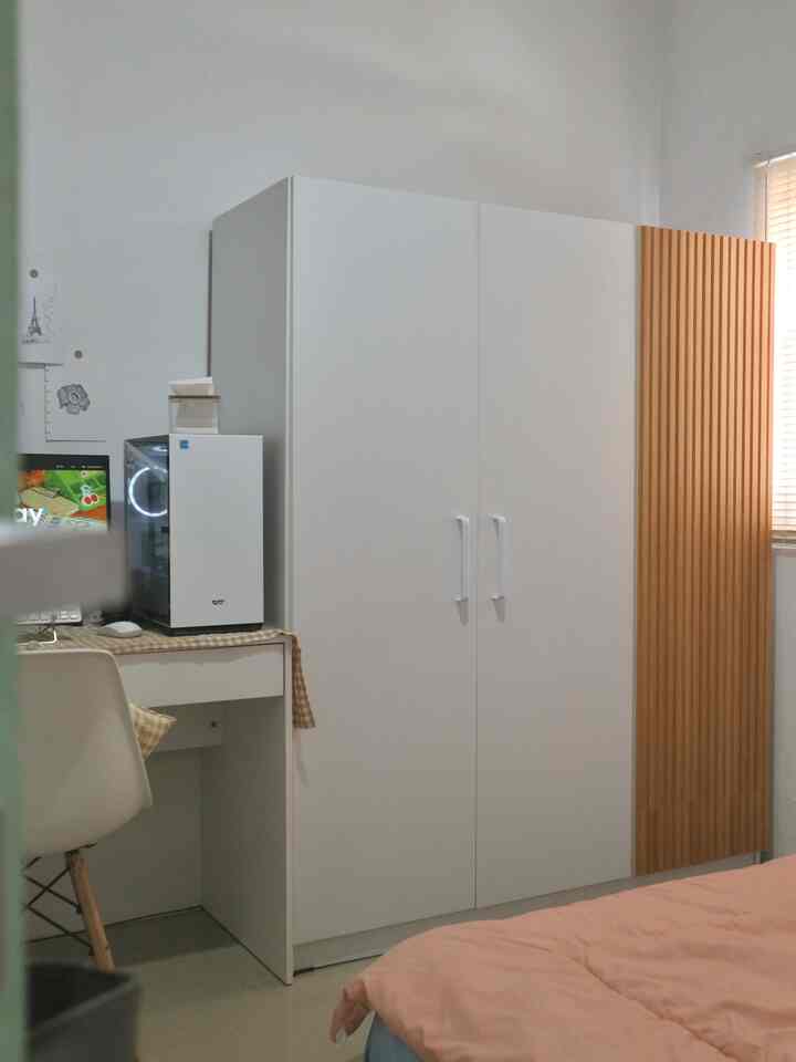 Bright white and wood tone bedroom featuring a 3-door wardrobe with a wood panel accent creating a clean and cozy atmosphere