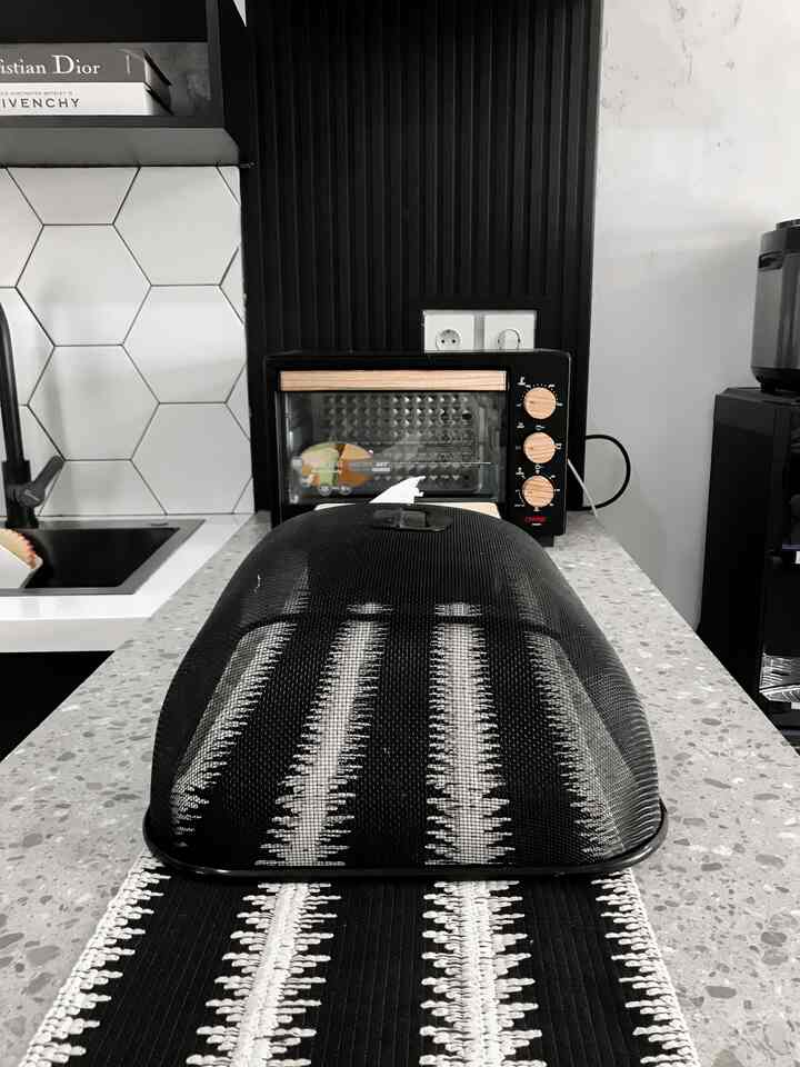 Modern, sleek kitchen featuring a white and black kitchen island centered with organized appliances