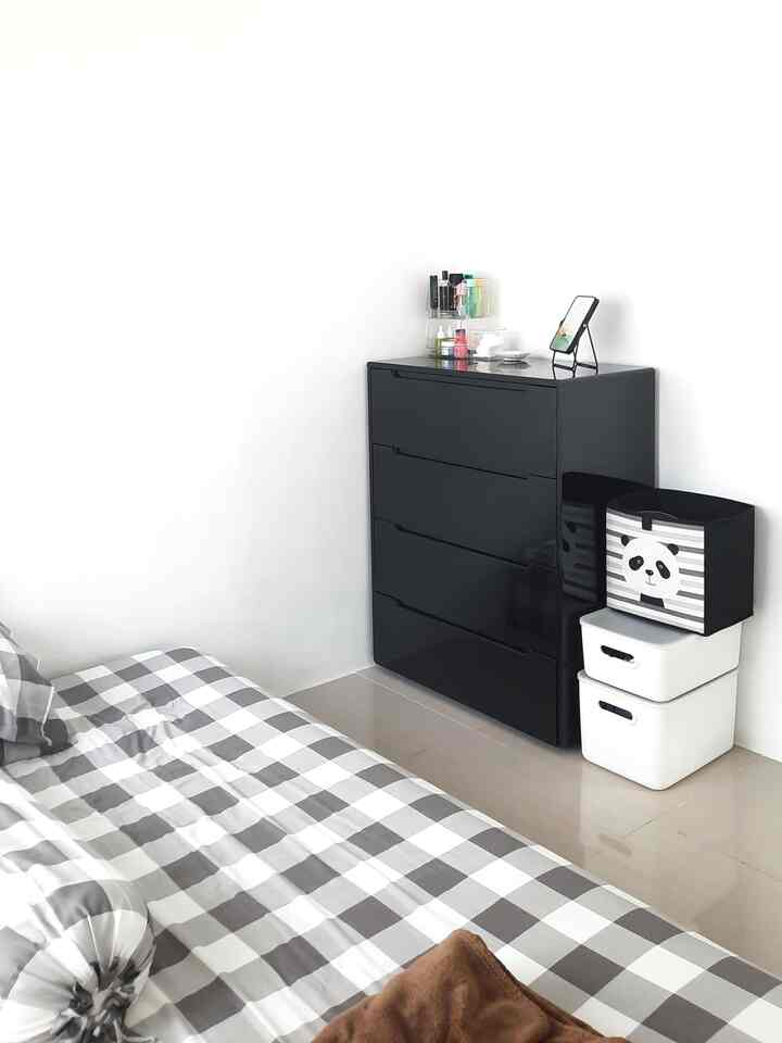 White and black toned bedroom featuring a bed and a chest of drawers in a clean, compact space