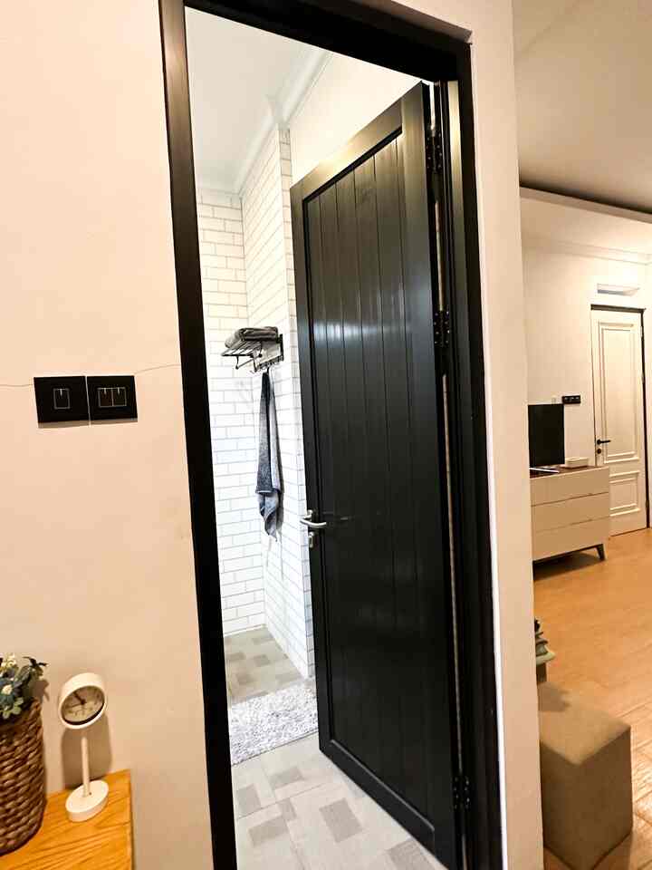 Black and white bathroom entrance featuring tiled walls and hanging towel, creating a simple, clean space