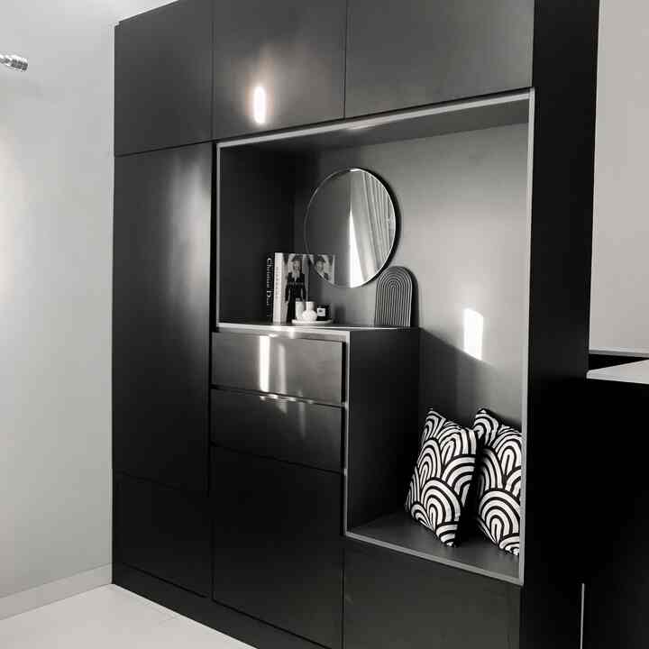 Monotone and black built-in closet with cushions in a minimalist room space