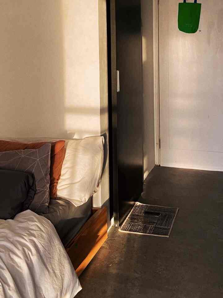 White and brown toned bedroom in a studio apartment featuring bed and natural modern cozy atmosphere