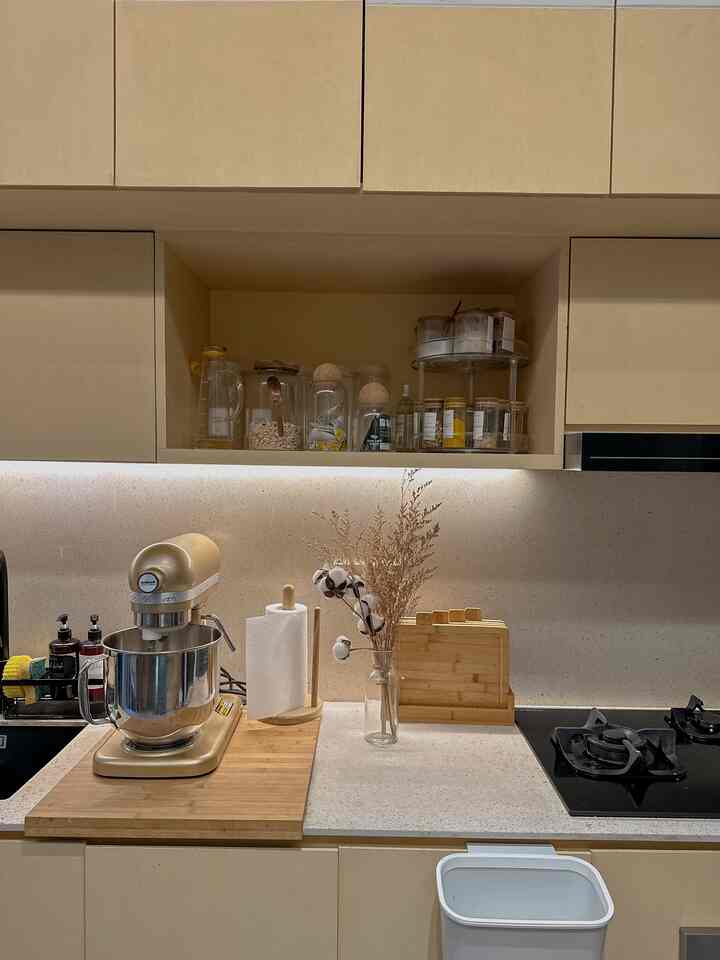 Natural color and wood tone small kitchen featuring transparent glass vase and cutting board in a simple setting