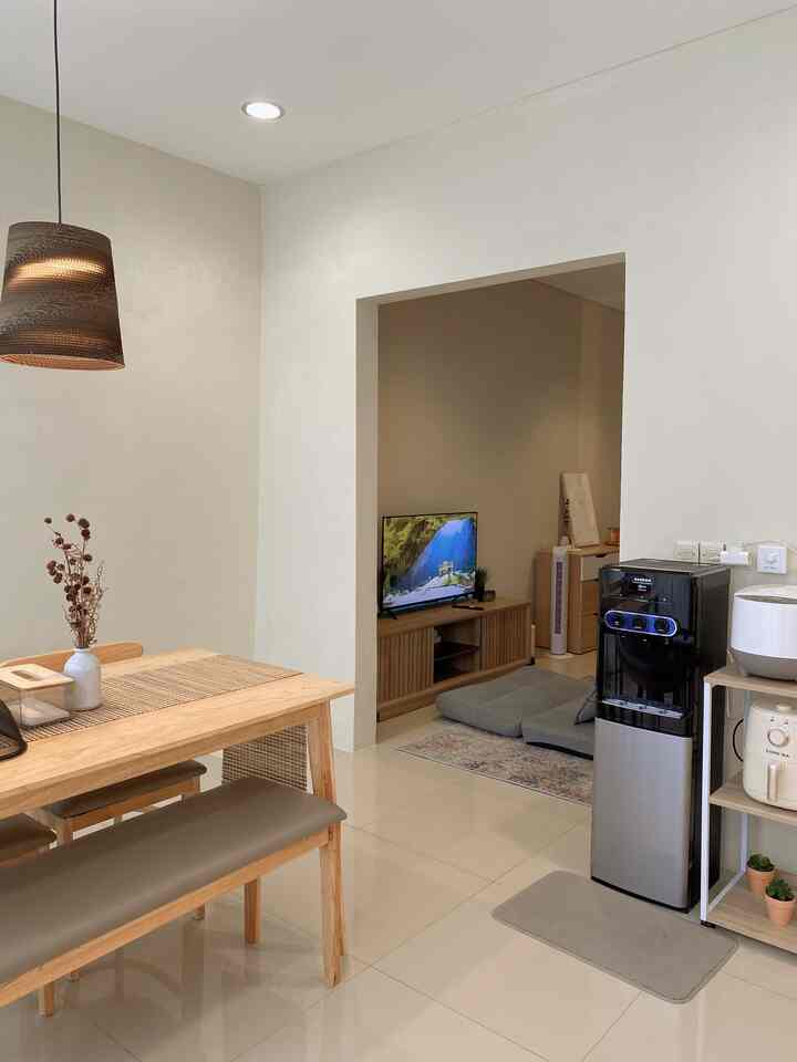 Cozy dining room and living room area with beige and natural wood tones creating a warm atmosphere