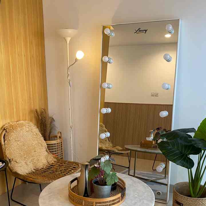 Wood tone and light brown entrance featuring a rattan chair and large vanity mirror, creating a cozy atmosphere