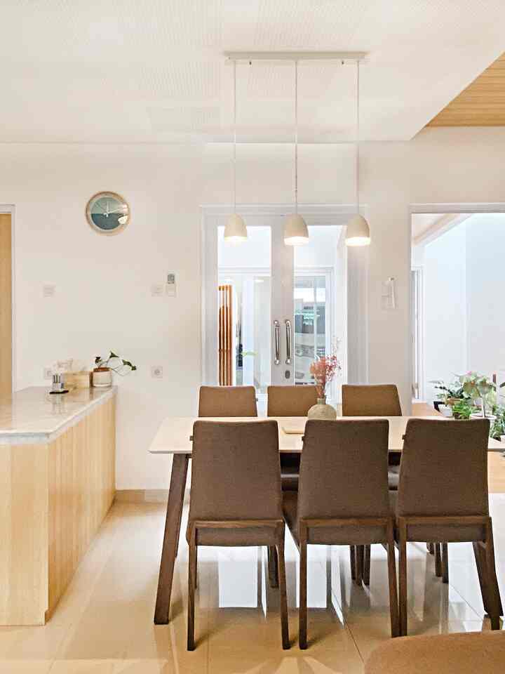 White and brown toned dining room featuring a rectangular dining table with six chairs, creating a clean and natural atmosphere