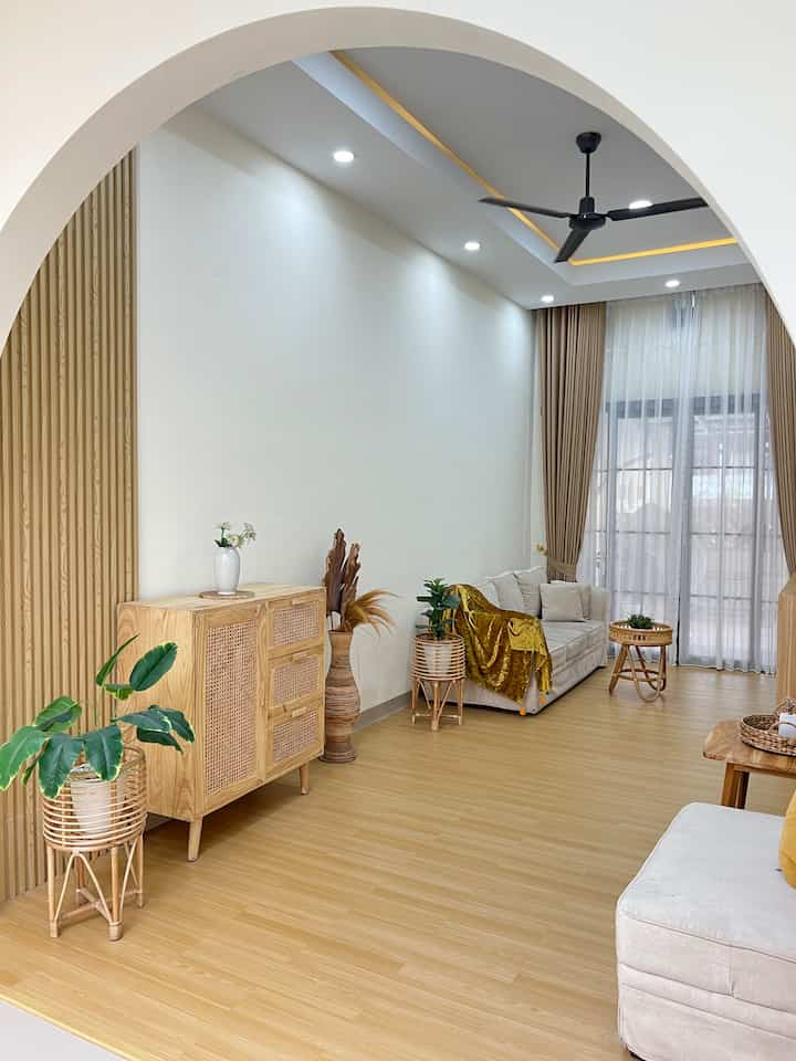 White and brown toned living room featuring wooden and rattan furniture with a natural and clean atmosphere
