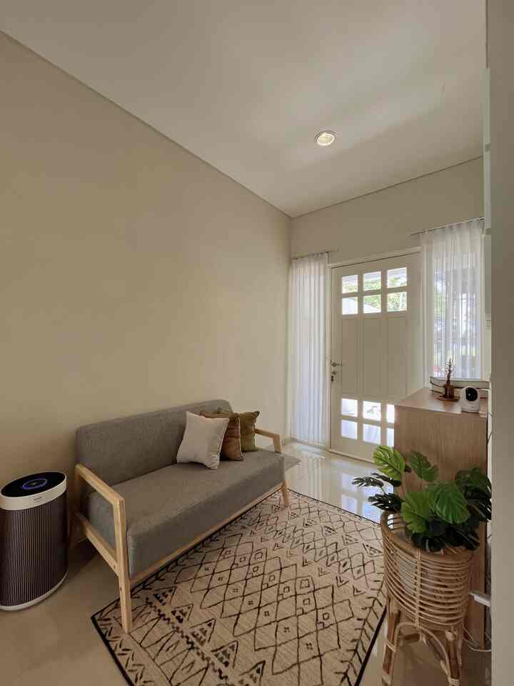 A compact 2x3m beige and wood tone living room featuring a gray sofa and patterned carpet with a simple, warm atmosphere