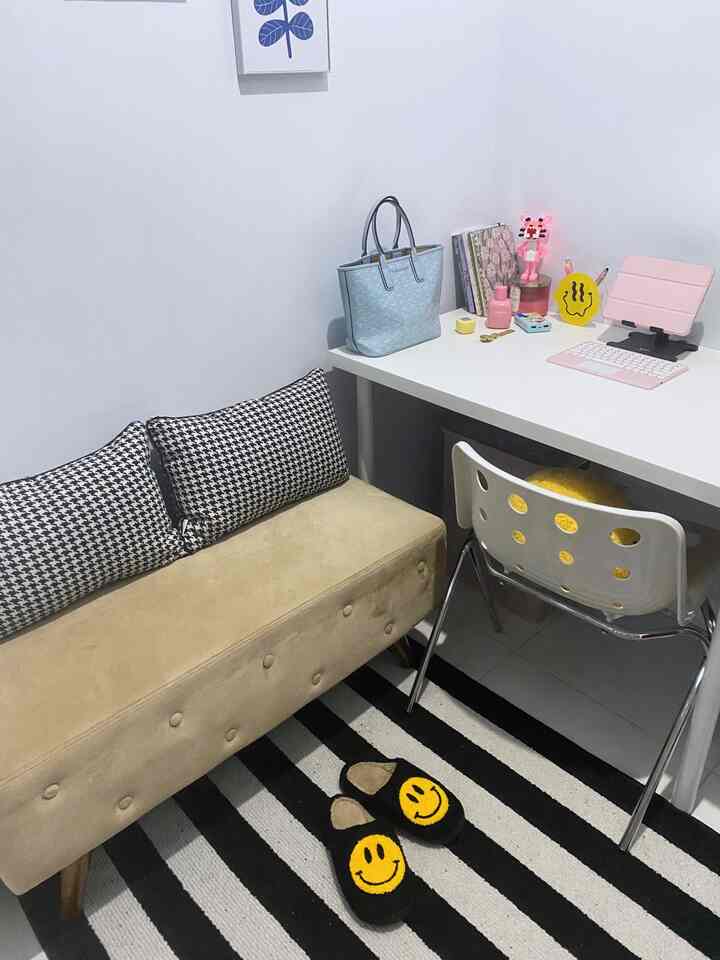 White-toned minimalist home office with a beige sofa and a black-and-white striped carpet creating a cozy atmosphere