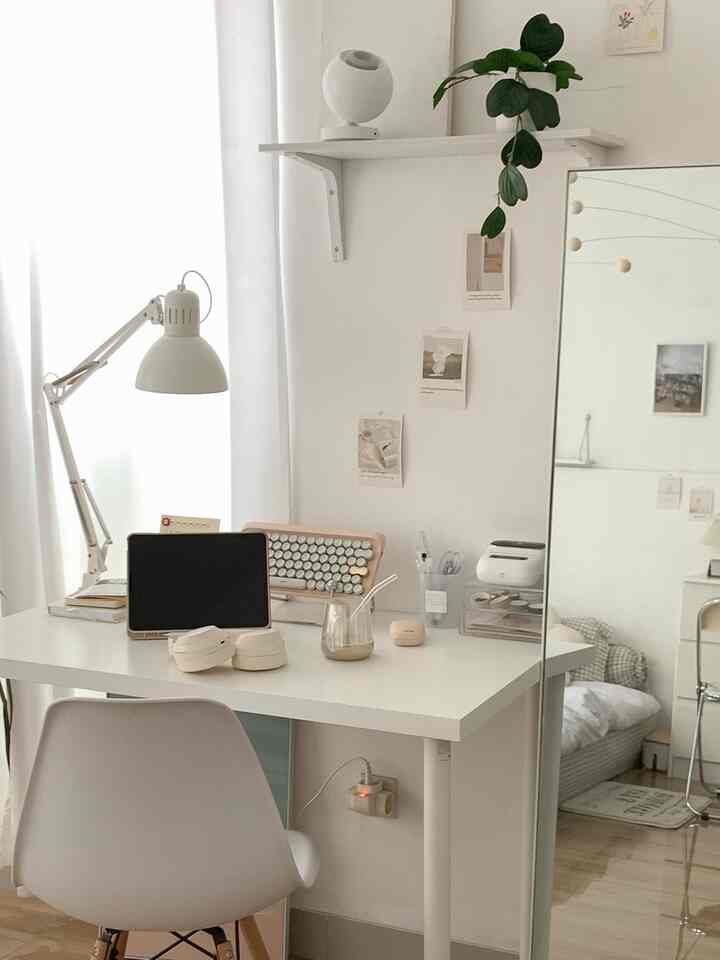 White-toned bedroom combined with home office, featuring simple desk and chair with a clean atmosphere