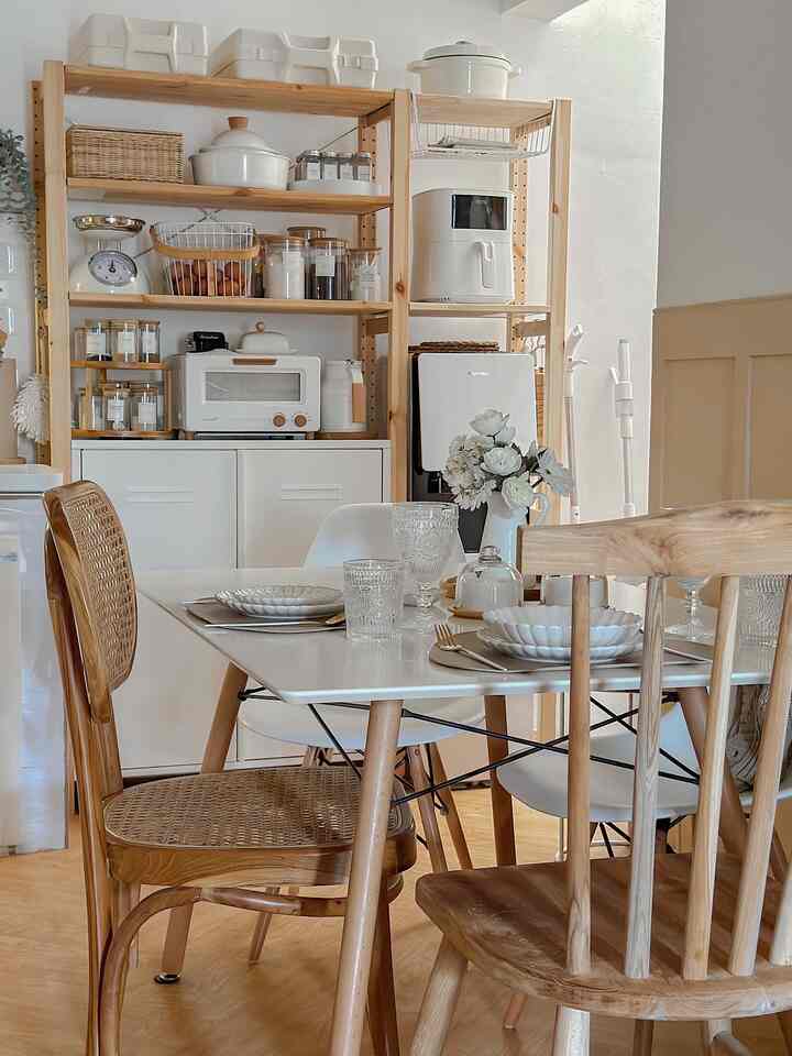 White and wood-toned dining room featuring natural furniture and storage solutions in a cozy, minimalist setting