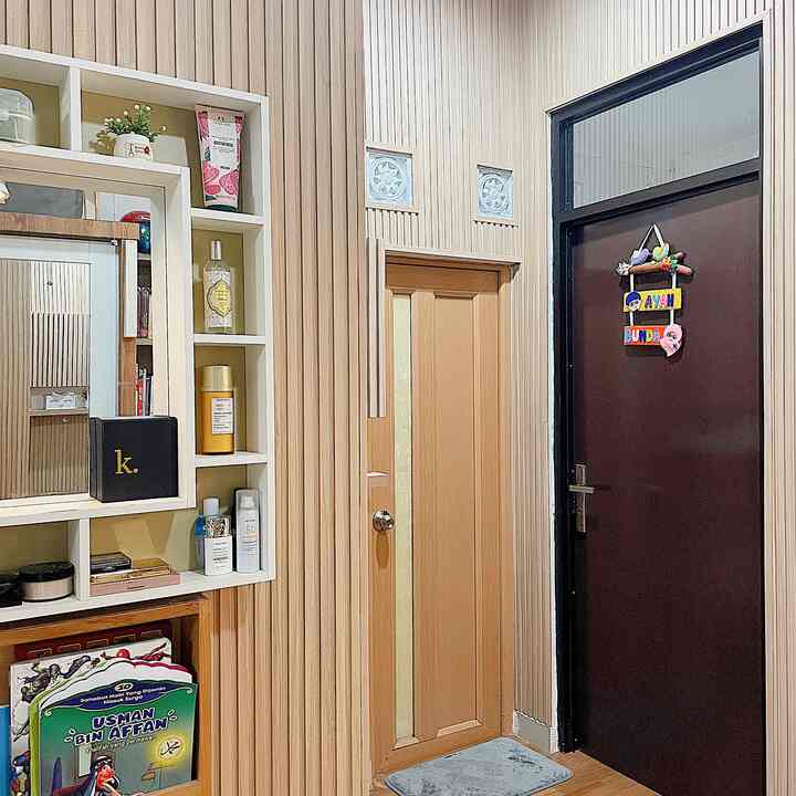 Beige and wood tone studio apartment entrance featuring wall storage with a cozy atmosphere