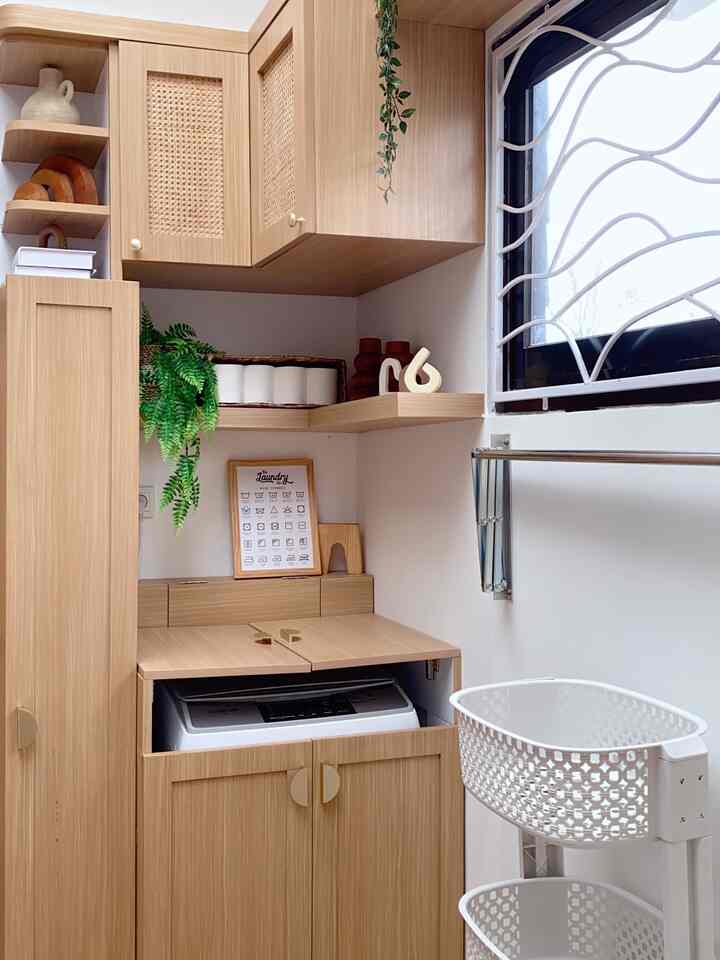 Bright and tidy laundry room with natural wood tone cabinets, white plastic baskets, and a window with unique grille design