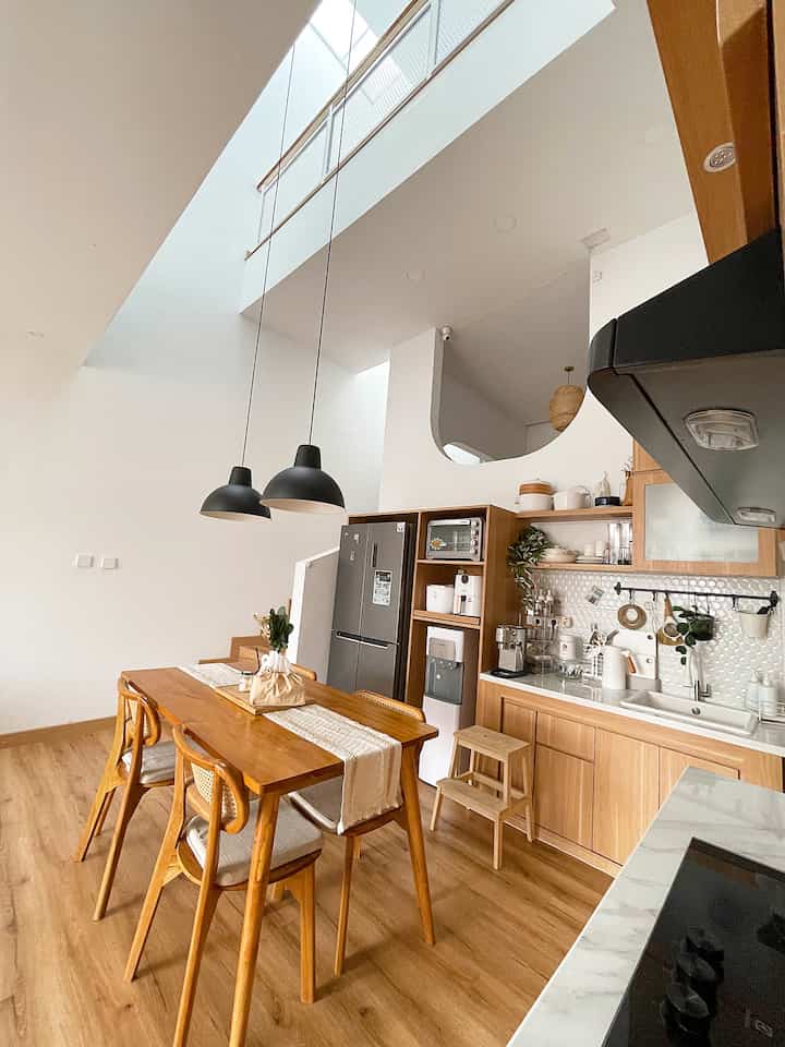 Bright beige wood-tone kitchen and dining room featuring a 4-person dining table with natural modern style