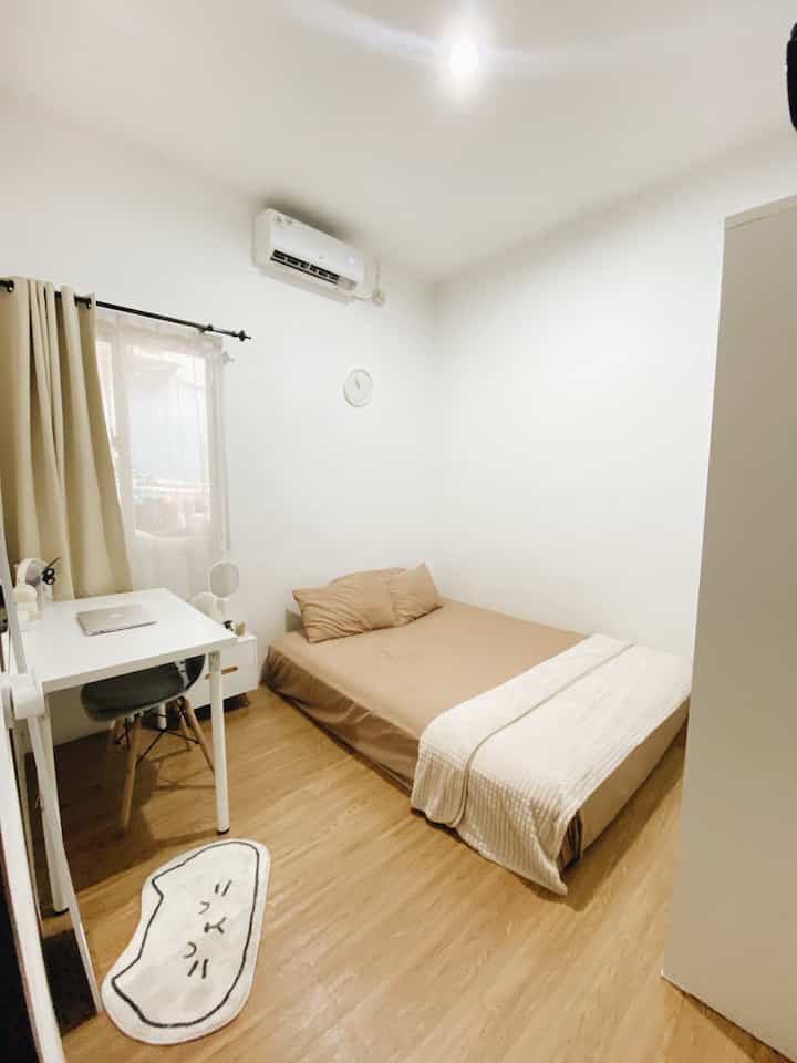 Light brown flooring and white-walled 9sqm bedroom featuring a minimal single bed and desk with a clean atmosphere