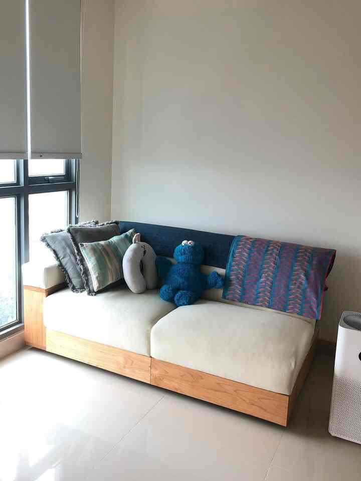 Natural-toned two-seater sofa bed placed in a clean and cozy living room space