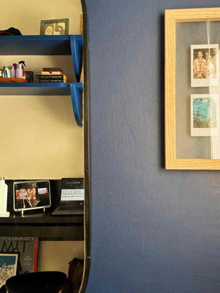 Blue-toned shelves and beige walls in a home office space featuring a desk with laptop and tablet, creating a cozy study atmosphere