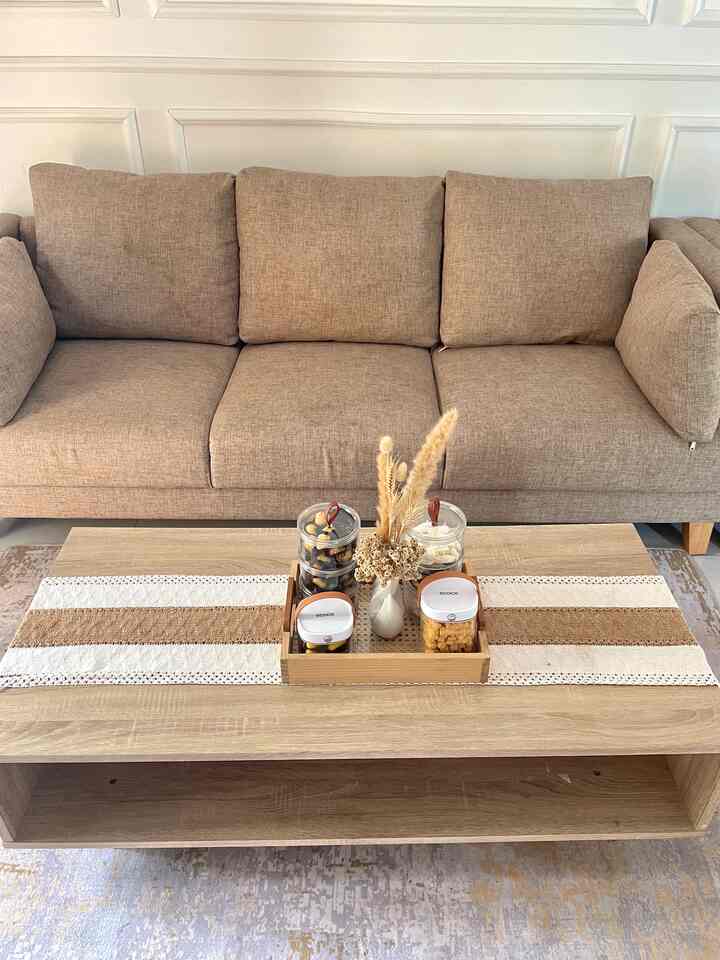 Beige and brown tone living room featuring natural sofa and table runner on a wooden coffee table, cozy atmosphere