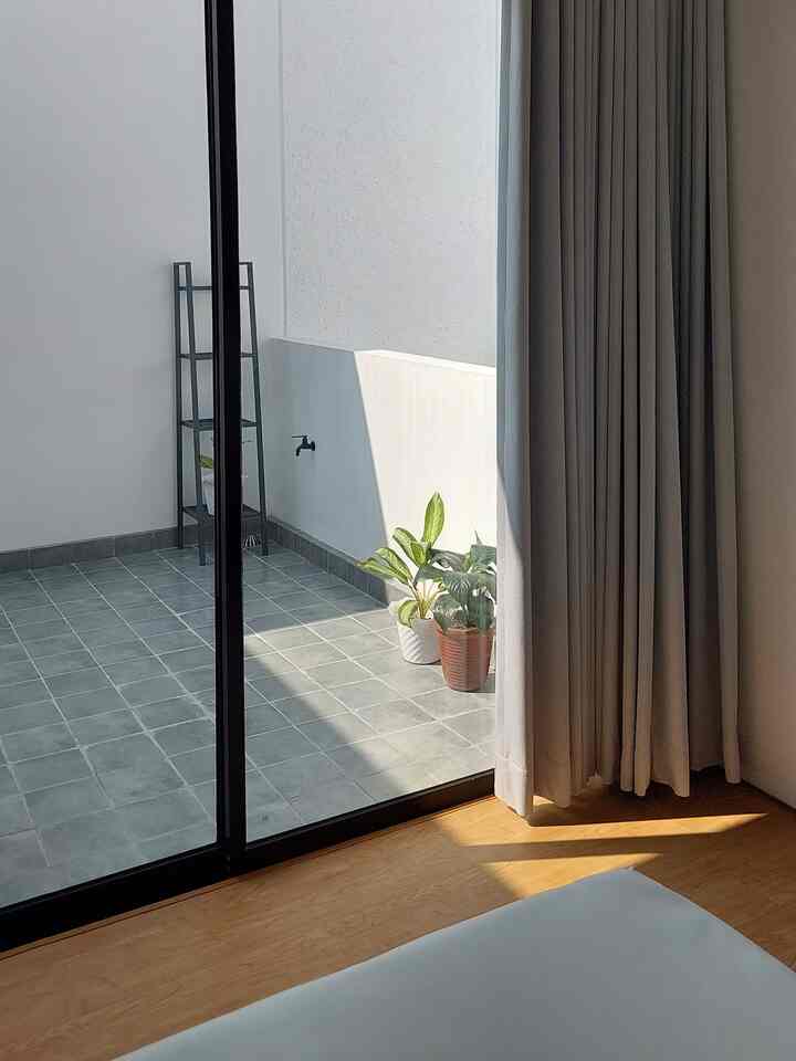 Natural color and wood tone bedroom featuring balcony and curtains with quiet, minimalistic atmosphere