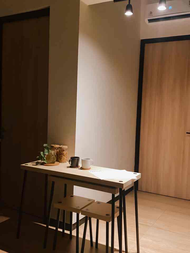 Natural toned small dining table with stools in a simple kitchen space