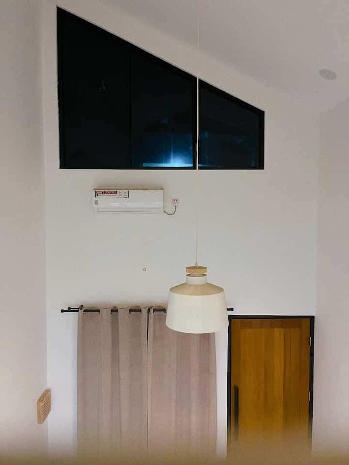 White and wood tone entrance space featuring a pendant light and curtains in a simple interior