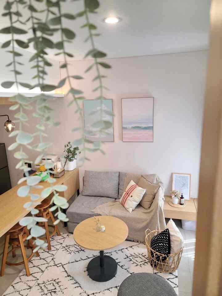 Natural color and wood tone compact Japandi living room featuring a gray sofa and round coffee table with cozy atmosphere
