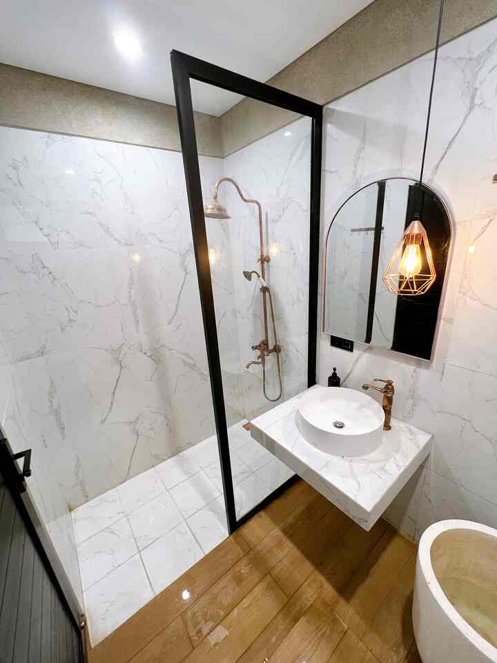 White and wood tone bathroom featuring marble tiles, round sink, and pendant lighting with a modern, trendy atmosphere