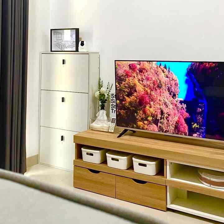 Simple living room of white and wood tones featuring TV stand and shoe cabinet with cozy atmosphere