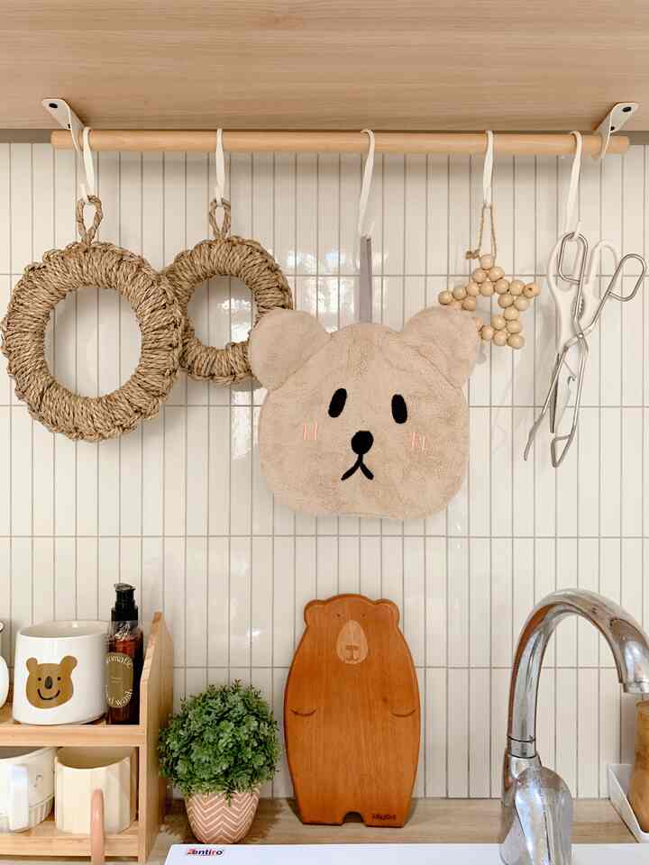 Natural-toned kitchen space featuring beige teddy bear towel, wood tone cutting board, and smart storage ideas for a tidy interior
