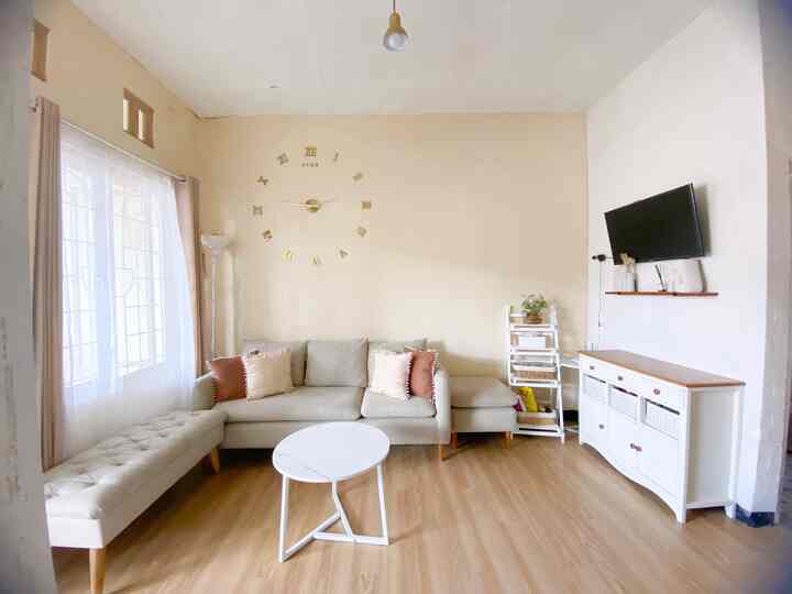 Bright white and warm toast toned 4.5-tatami living room featuring minimalist sofa, bench stool, and round coffee table with cozy atmosphere