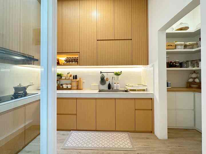 Wood tone and white kitchen featuring clean, minimal Japandi style with practical cabinetry and open pantry space