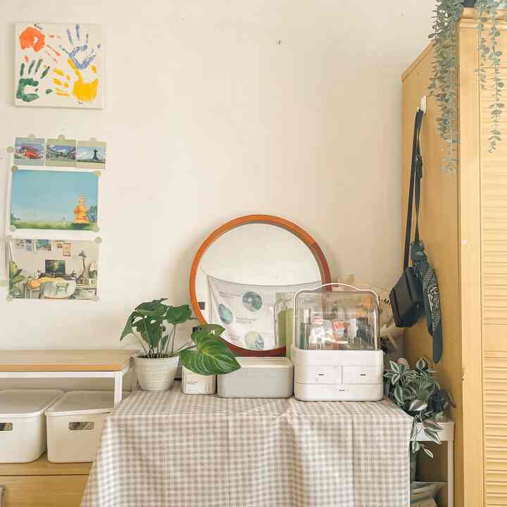 Beige and natural toned bedroom featuring a vintage round mirror and plants with a simple, calm atmosphere