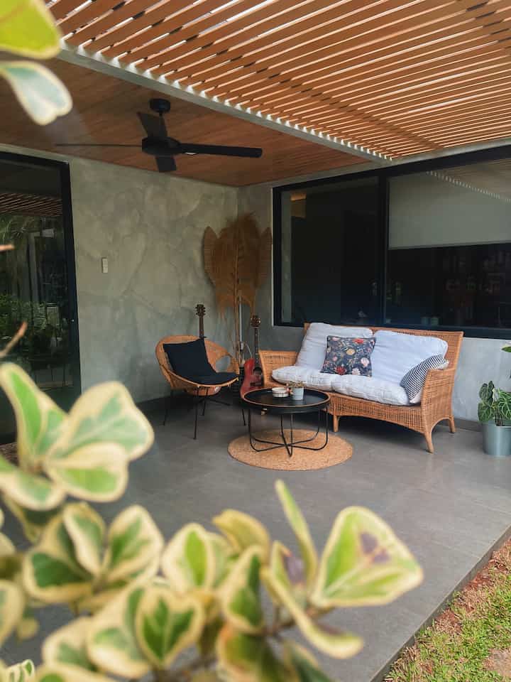 Natural-toned balcony space featuring rattan sofa, armchair, and round coffee table for a cozy outdoor lounge