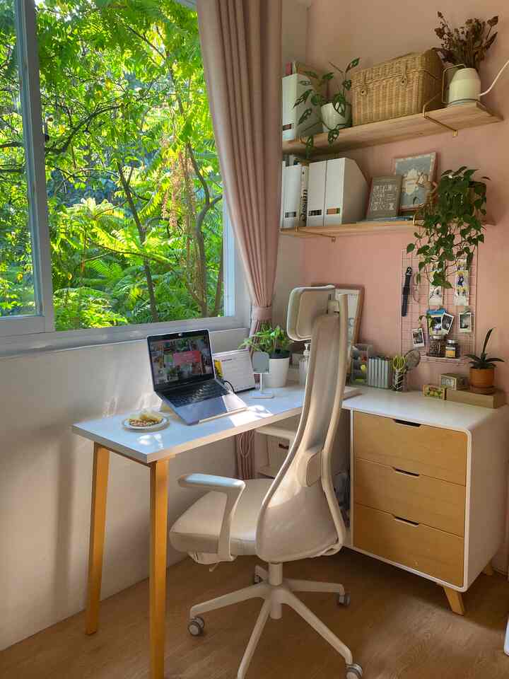 Area Kerja di Rumah yang Terinspirasi dari Cafe

Sebagai freelancer graphic designer & content creator, aku sangat memahami pentingnya membangun area kerja yang nyaman. Baik dari segi kenyamanan untuk duduk berlama-lama di depan laptop sampai ambience ruangan sekitar yang dapat membantuku untuk mengeluarkan ide-ide kreatif ketika bekerja.

Berawal dari kebiasaan ketika kuliah di Bandung, aku sulit sekali untuk berkonsentrasi ketika mengerjakan tugas di kosan. Sehingga cafe-cafe Bandung yang aesthetic menjadi tempat ternyamanku untuk berkreatifitas. Ada satu cafe di Bandung yang menjadi sumber inspirasiku, yaitu Delicacies. Memiliki desain feminim dengan ornamen artdeco contemporer yang memadukan tanaman indoor. Interior dari cafe inilah yang menjadi “dream wishlist” desain rumahku.

Walaupun kini aku kembali ke planet lain yang panas (dibaca: Bekasi), aku ingin menghadirkan “vibe cafe Bandung” lagi di kamarku. Sehingga aku merenovasi kamar kosong di rumah yang kebetulan berhadapan dengan kebon ini. Aku mendesain kamar tidur & area kerja dengan bukaan lebar agar ruangan lebih terang dan sirkulasi udara lebih baik. 

Desain kamar tidur ini memiliki focal point di area kerja, sehingga meja kerja ditaruh menghadap jendela. Untuk kenyamananku ketika bekerja, aku menggunakan kursi IKEA JARVFJALLET. Selain fitur kursi kerjanya yang ergonomis, desain kursi ini memiliki bentuk yang minimalis dan berwarna putih secara keseluruhan sehingga cocok pada interior kamar tidurku.

Untuk menaruh perlengkapan gambar, tools digital, dan hasil print kertas A2, meja helsinki multi table dari iFURNHOLIC ini sangat membantu. Karena bisa merapihkan barang-barang kerjaku yang banyak ini ke dalam satu kompartemen meja. Sebagai penyimpanan tambahan, aku menambahkan rak dinding untuk menaruh dokumen. Agar terlihat aesthetic, aku mengkombinasikan penataan rak dengan cover buku desain dan tanaman-tanaman asli untuk menambah kesegaran ruangan.

#BTNOASeason4 #WFH #homeoffice #cafeinspired