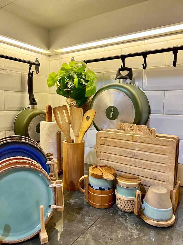 Wood tone and natural color kitchen space featuring various kitchen utensils and plates arranged in a cozy setting