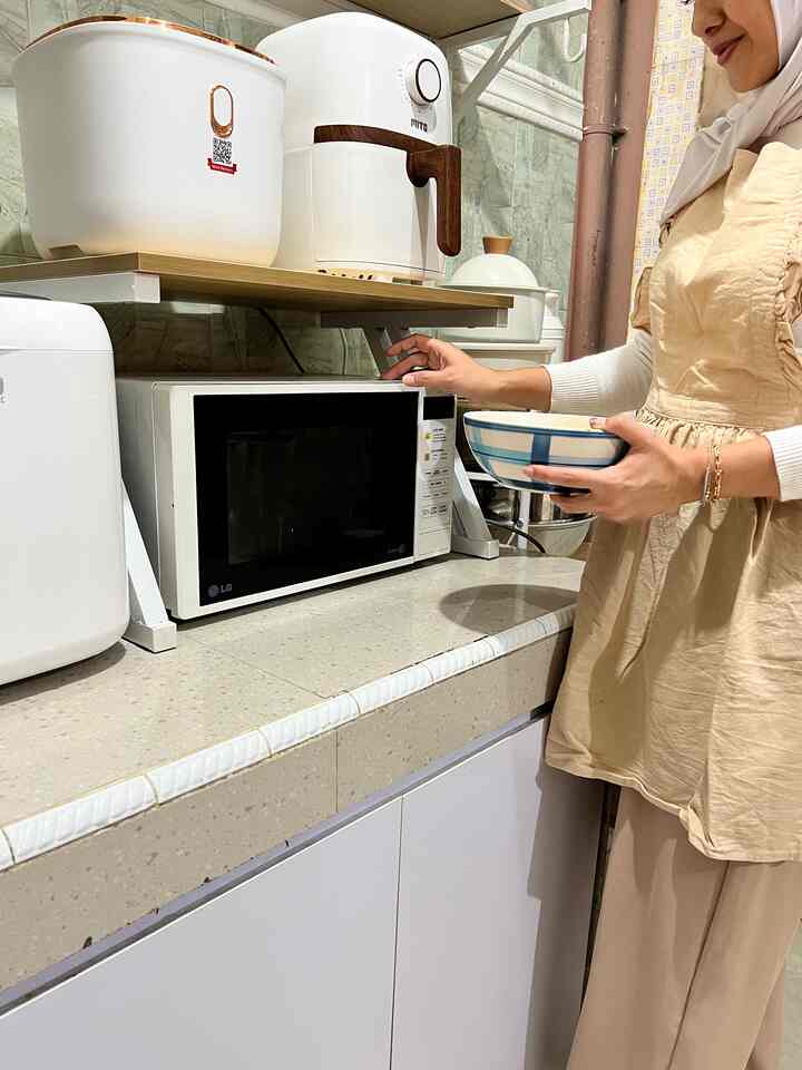 Beige and white toned kitchen space featuring microwave and airfryer appliances neatly arranged on countertop