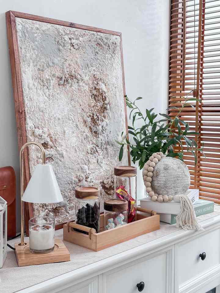 White and wood tone entrance storage area, featuring transparent glass jars and a tray with snacks in a cozy arrangement