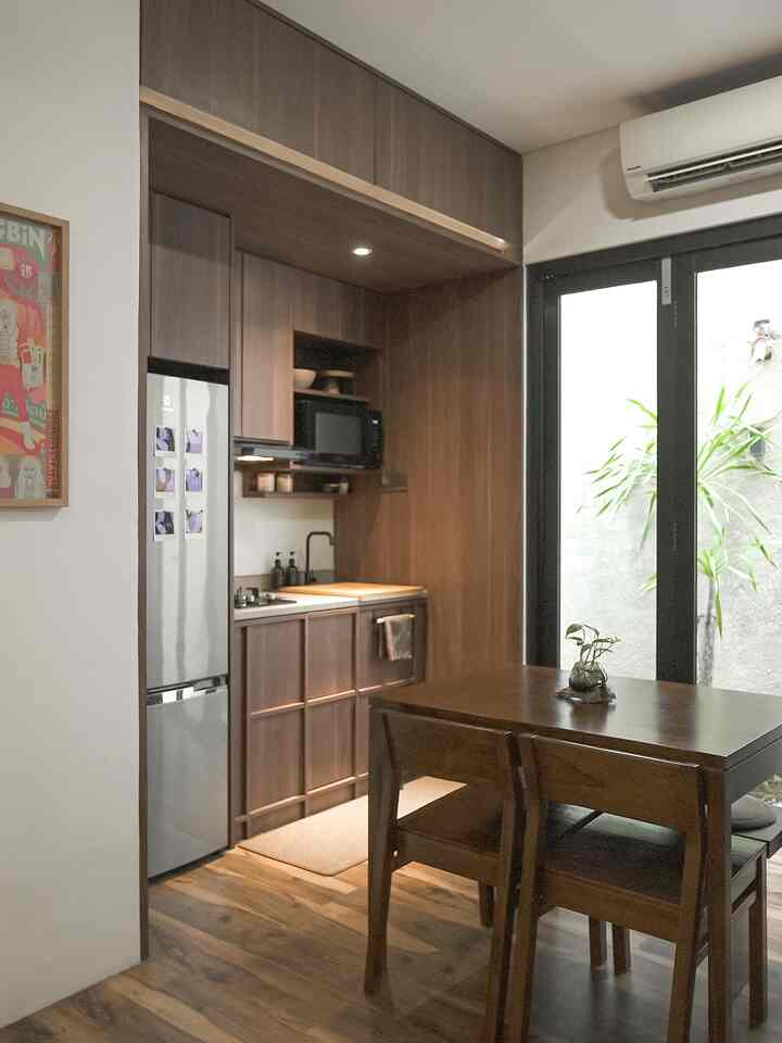 Wood tone and white kitchen and dining room featuring wooden furniture and large glass doors with bright natural light