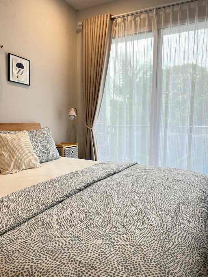 A 6-tatami bedroom with beige and white sheer curtains, featuring a bed for two-person household filled with bright natural light.