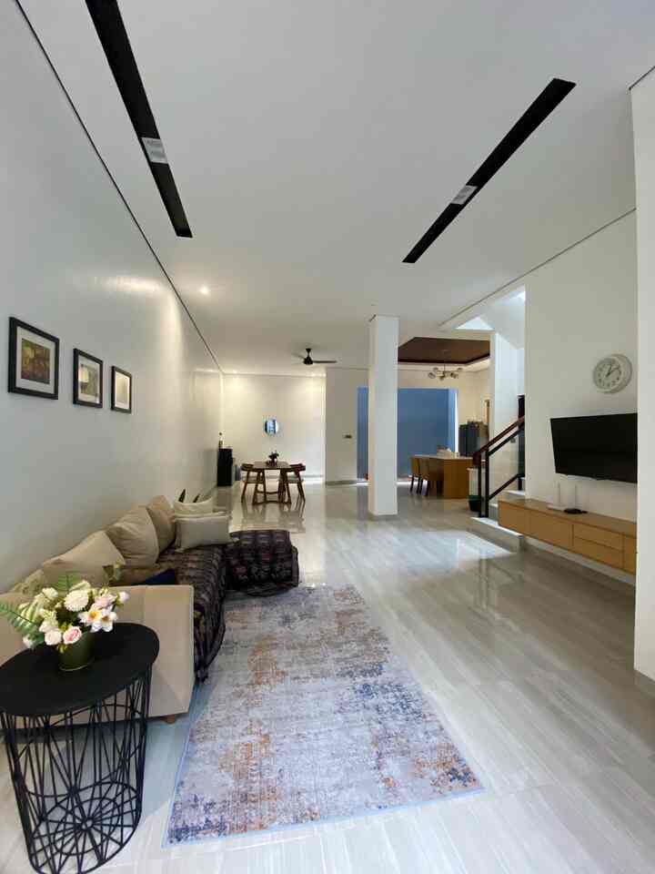 Bright and spacious living and dining area with beige sofa and wooden dining table in a natural modern interior