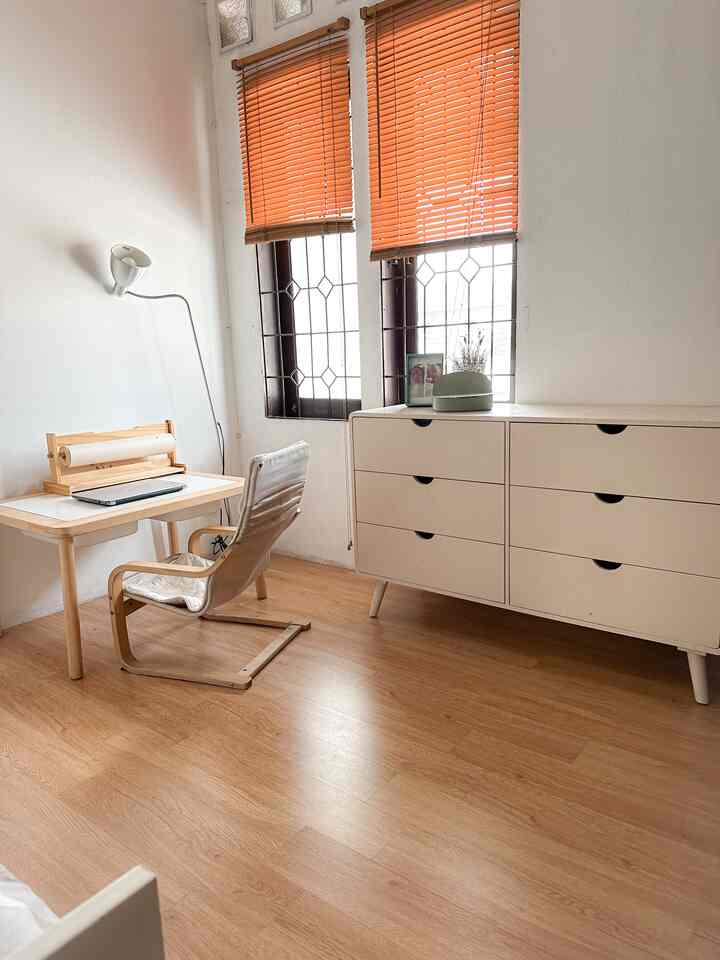 Natural color and white-toned kids' room featuring desk, dresser, and armchair in a clean, bright space
